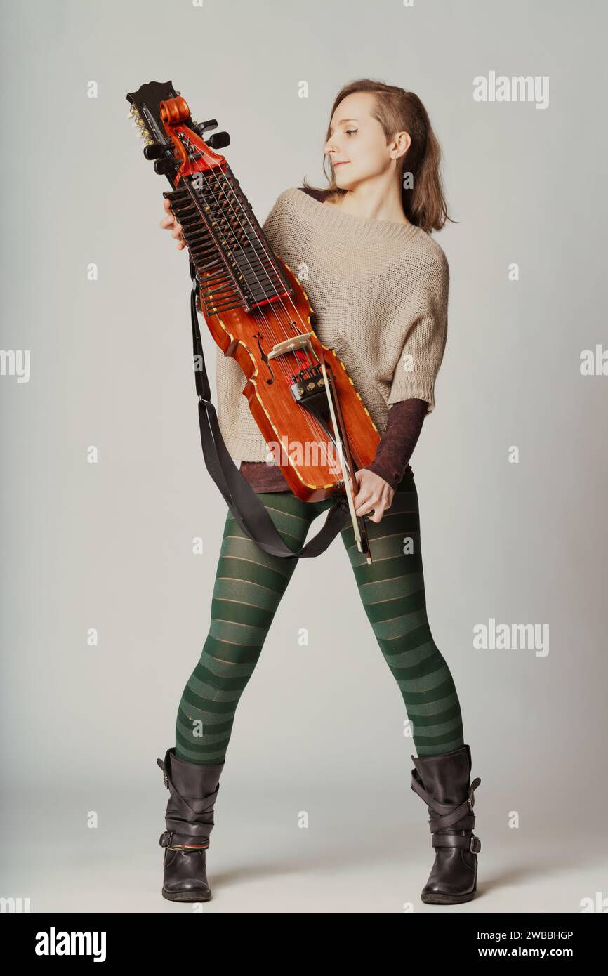 Die Stimmung des Spielers und die Eleganz des Nyckelharpa erzählen eine Geschichte von musikalischer Hingabe und kultureller Vermächtnis Stockfoto
