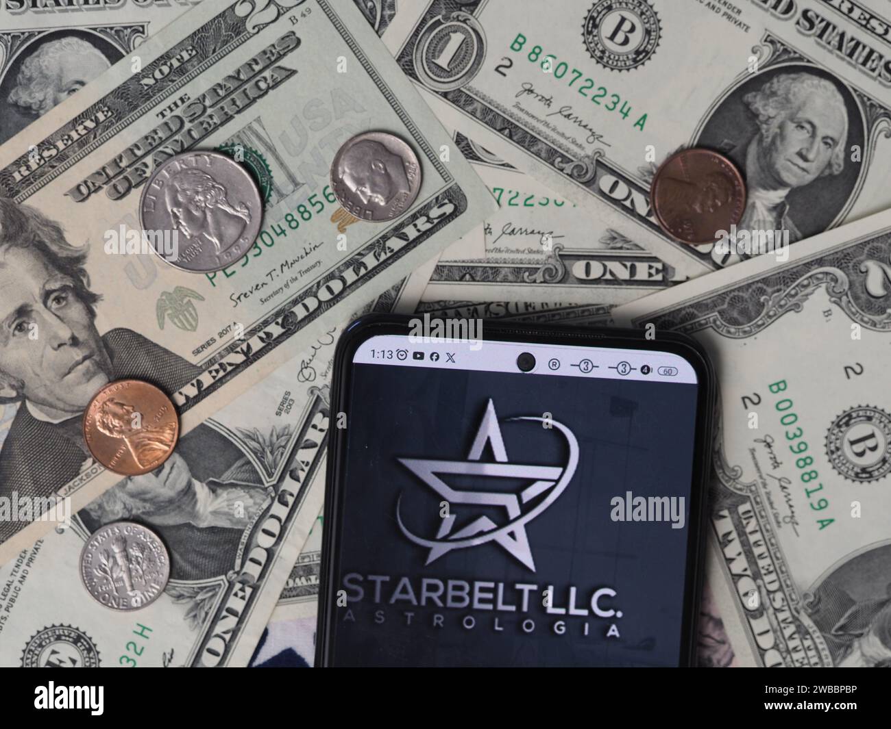 Bayern, Deutschland - 10. Januar 2024: In dieser Fotoabbildung wird ein Starbelt LLC Logo auf einem Smartphone mit US-Dollar-Noten und angezeigt Stockfoto