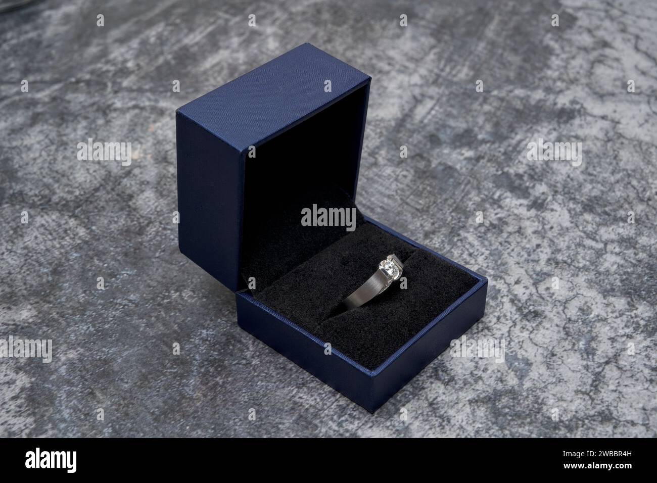 Ein Platin-Ring mit eingeschlossenen Diamanten in einem blauen Gehäuse Stockfoto