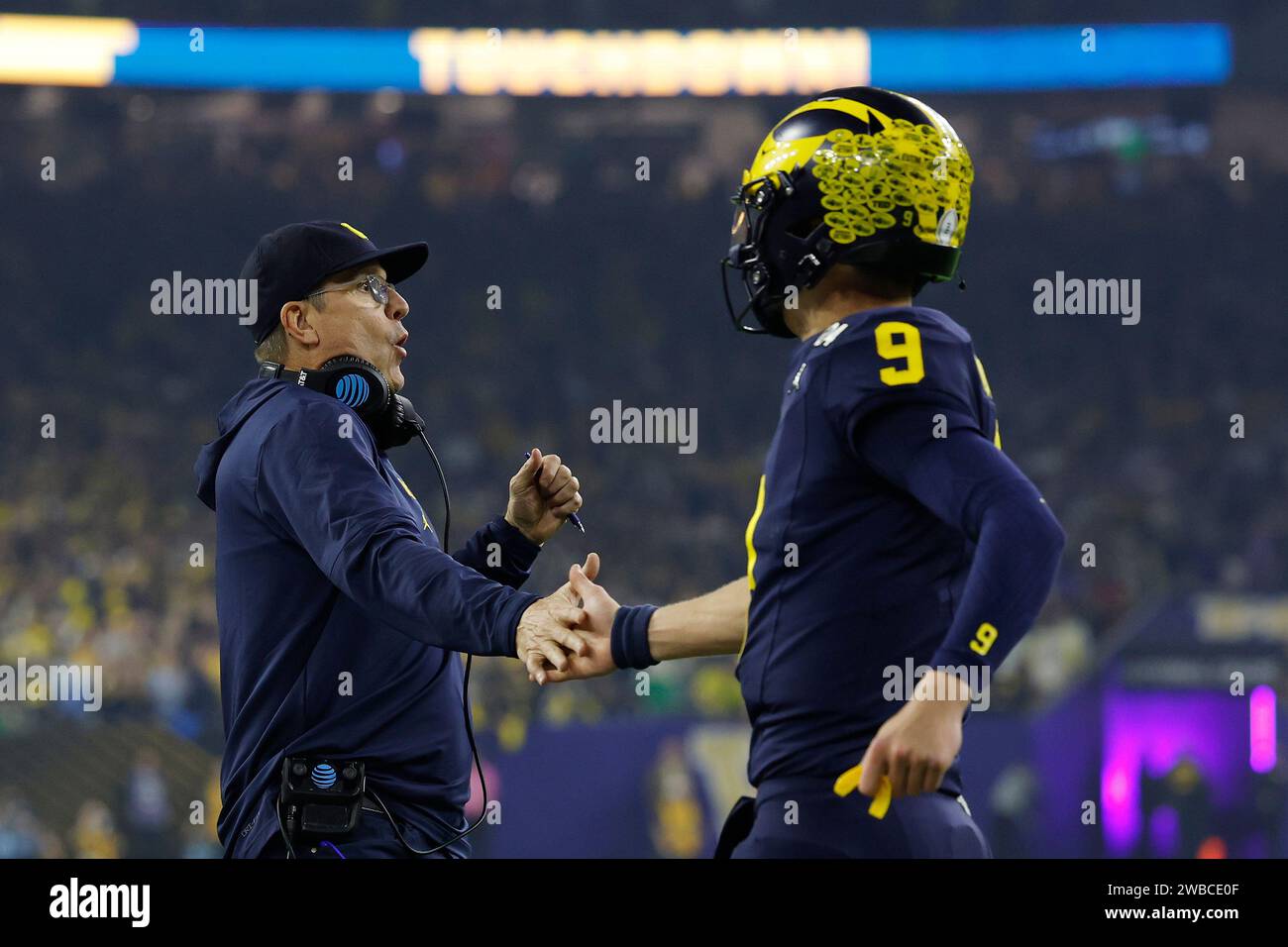 HOUSTON, Texas – 08. JANUAR: Jim Harbaugh, Cheftrainer von Michigan Wolverines, feiert mit Quarterback J.J. McCarthy (9) während der CFP National Championship gegen die Washington Huskies am 08. Januar 2024 im NRG Stadium in Houston, Texas. (Foto: Joe Robbins/Image of Sport) Stockfoto