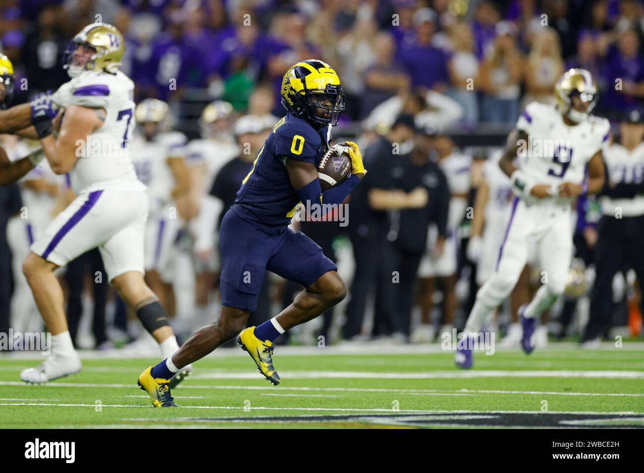 HOUSTON, Texas – 08. JANUAR: Michigan Wolverines Defensivback Mike Sainristil (0) läuft mit dem Ball, nachdem er im vierten Quartal der CFP National Championship gegen die Washington Huskies am 08. Januar 2024 im NRG Stadium in Houston, Texas, abgefangen hatte. (Foto: Joe Robbins/Image of Sport) Stockfoto