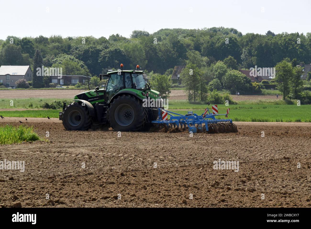 Landwirt mit Traktor und Kultivator bereitet Felder für Feldfrüchte vor, Herent, Belgien, Mai 2023 Stockfoto