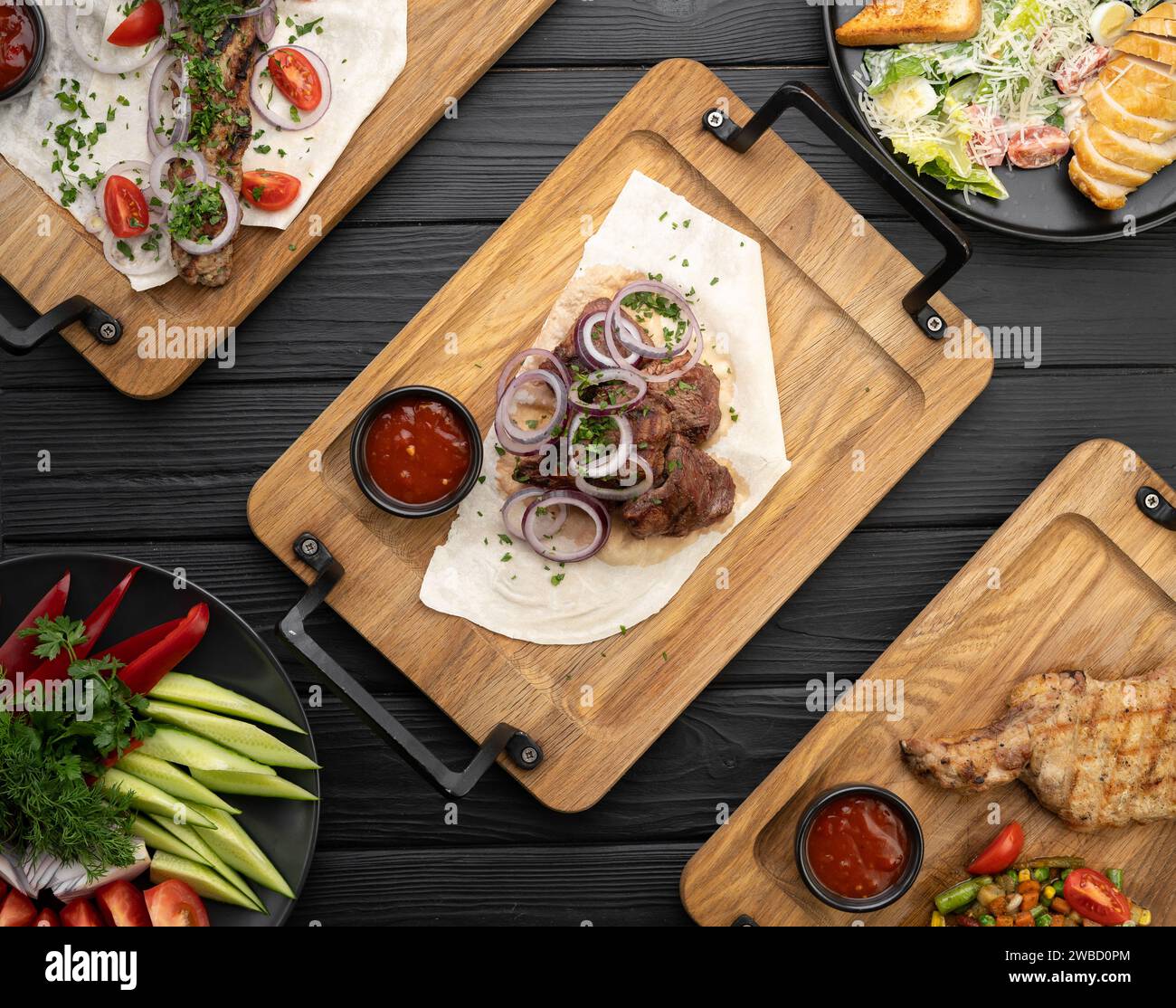 Mischen Sie Dönerfleisch, das auf einem schwarzen Tisch serviert wird. Kebab adana, Huhn, Lamm und Rindfleisch. Menü- und Rezeptkonzept, Draufsicht. Stockfoto