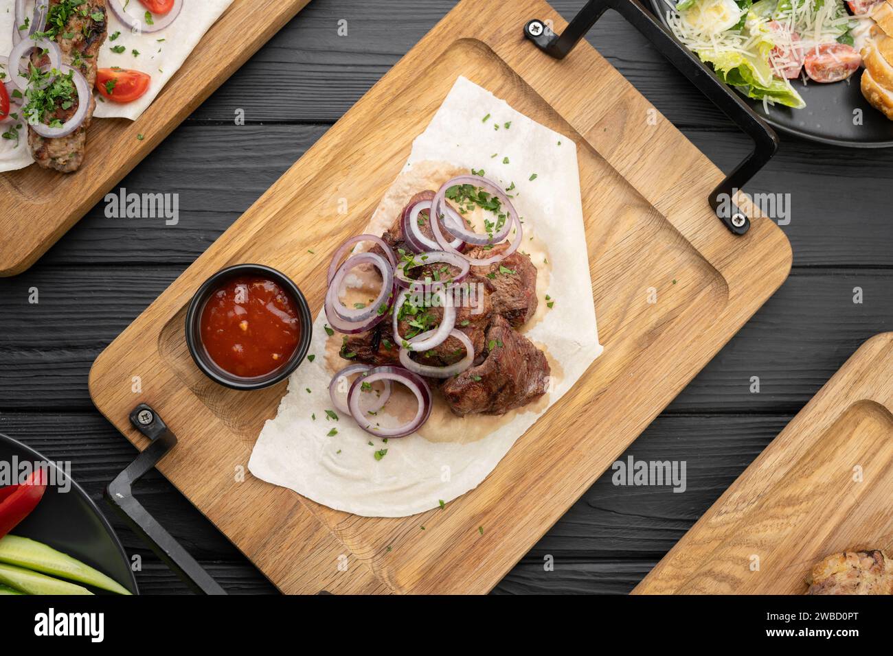 Mischen Sie Dönerfleisch, das auf einem schwarzen Tisch serviert wird. Kebab adana, Huhn, Lamm und Rindfleisch. Menü- und Rezeptkonzept, Draufsicht. Stockfoto