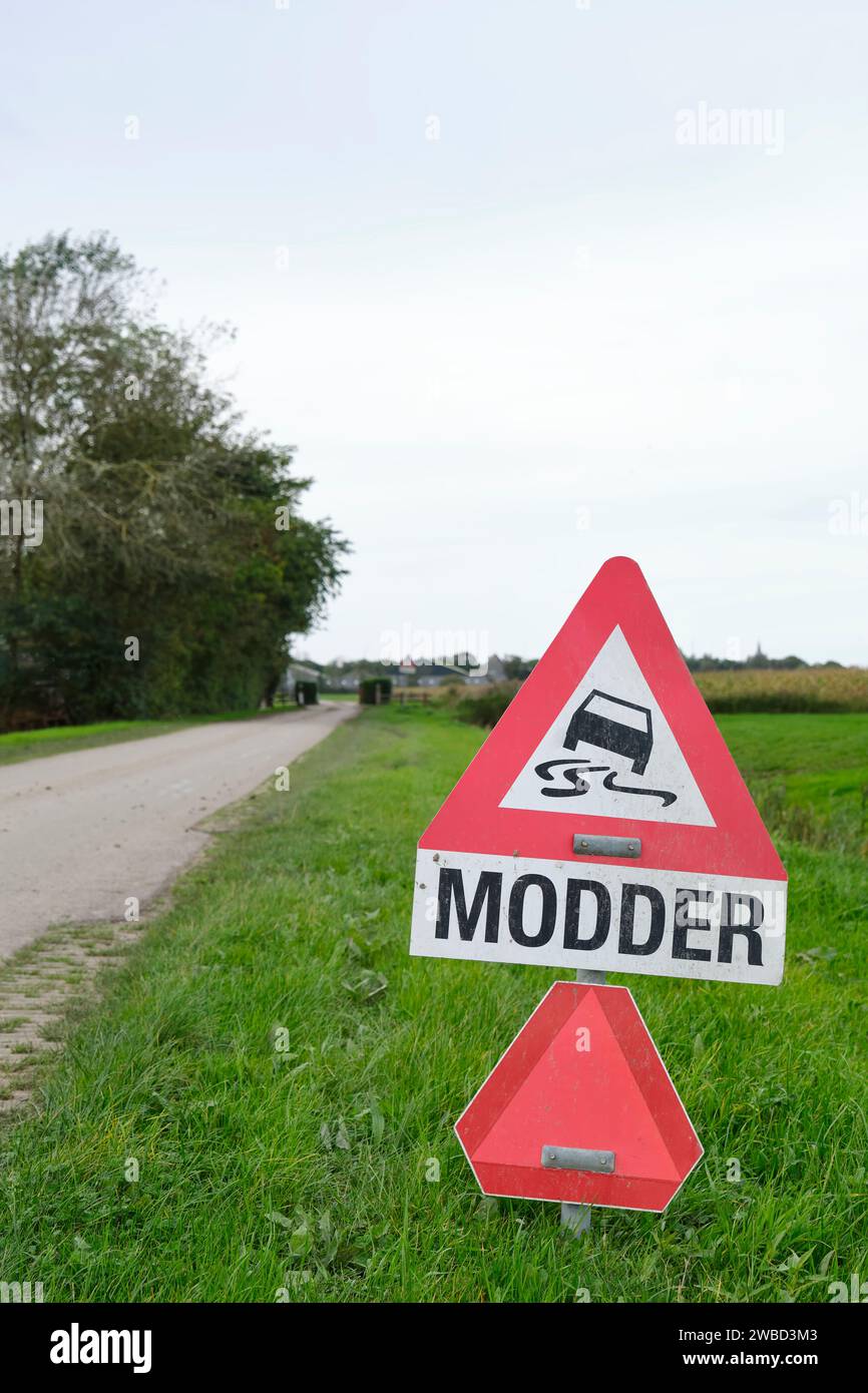 Warnschild für Schlamm oder Modder auf niederländisch auf der Straße in einer landwirtschaftlichen Umgebung. Schlamm kommt von den Bauern während der Ernte auf die Straße. Stockfoto