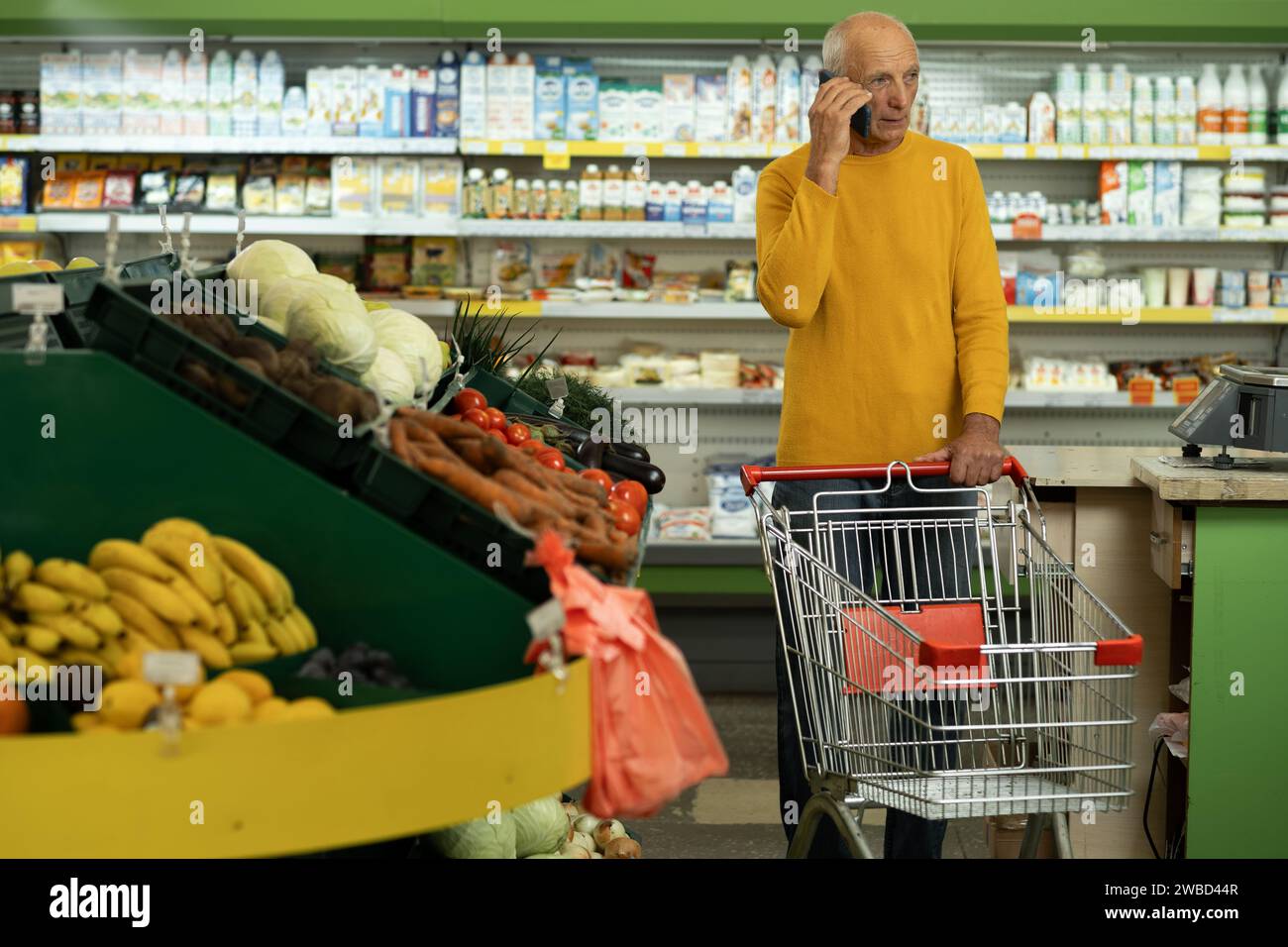 Supermarkt, Lebensmittelgeschäft, alter Mann telefoniert im Einzelhandel. Ermäßigte Speisen Stockfoto