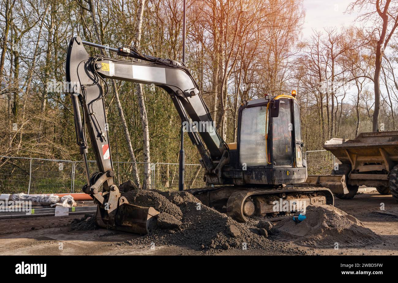 Bagger, der halbtrockene Betonmischung auf der Baustelle in den Kipper lädt Stockfoto