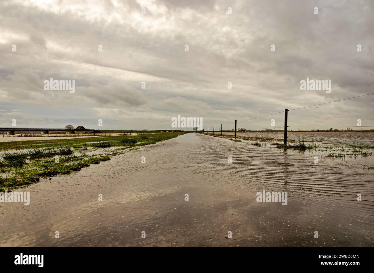 Werkendam, Niederlande, 29. Dezember 2024: Niedrigblick auf den Treshold, auf dem Wasser von den Auen in Richtung der Nebenkanäle fließt Stockfoto