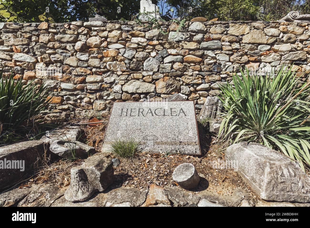 Ein in Stein gehauenes Schild mit der Aufschrift „Heraclea“ am Eingang zu Heraclea Lyncestis, einer antiken griechischen Stadt in der Nähe des heutigen Bitola in Nordmazedonien. Stockfoto