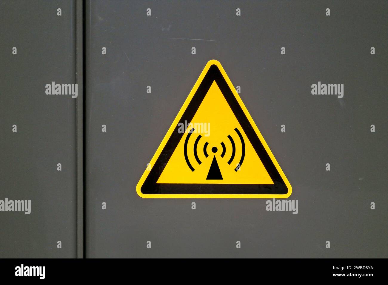 Gelbes Warnschild an einer Metalltür, das auf „nichtionisierende Strahlung“ hinweist. Stockfoto