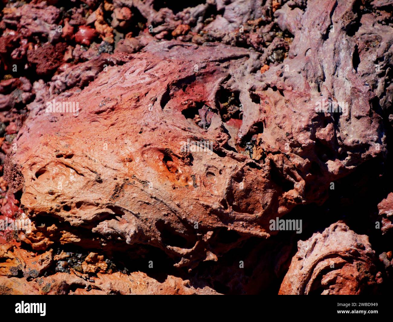 Detail der roten Felsen, raue Textur von Lavaströmen, die aus dem Vulkan Fournaise in Réunion, Frankreich ausbrechen. Pahoehoe Lavastein Stockfoto