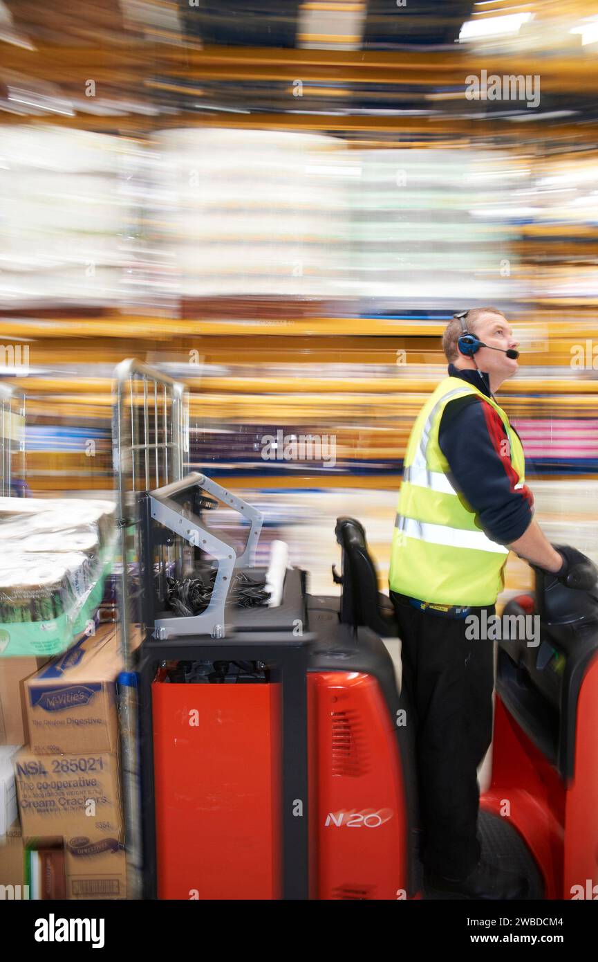 Mann auf Lkw bewegt sich in einem modernen Distributionslager in Südostengland, Großbritannien Stockfoto