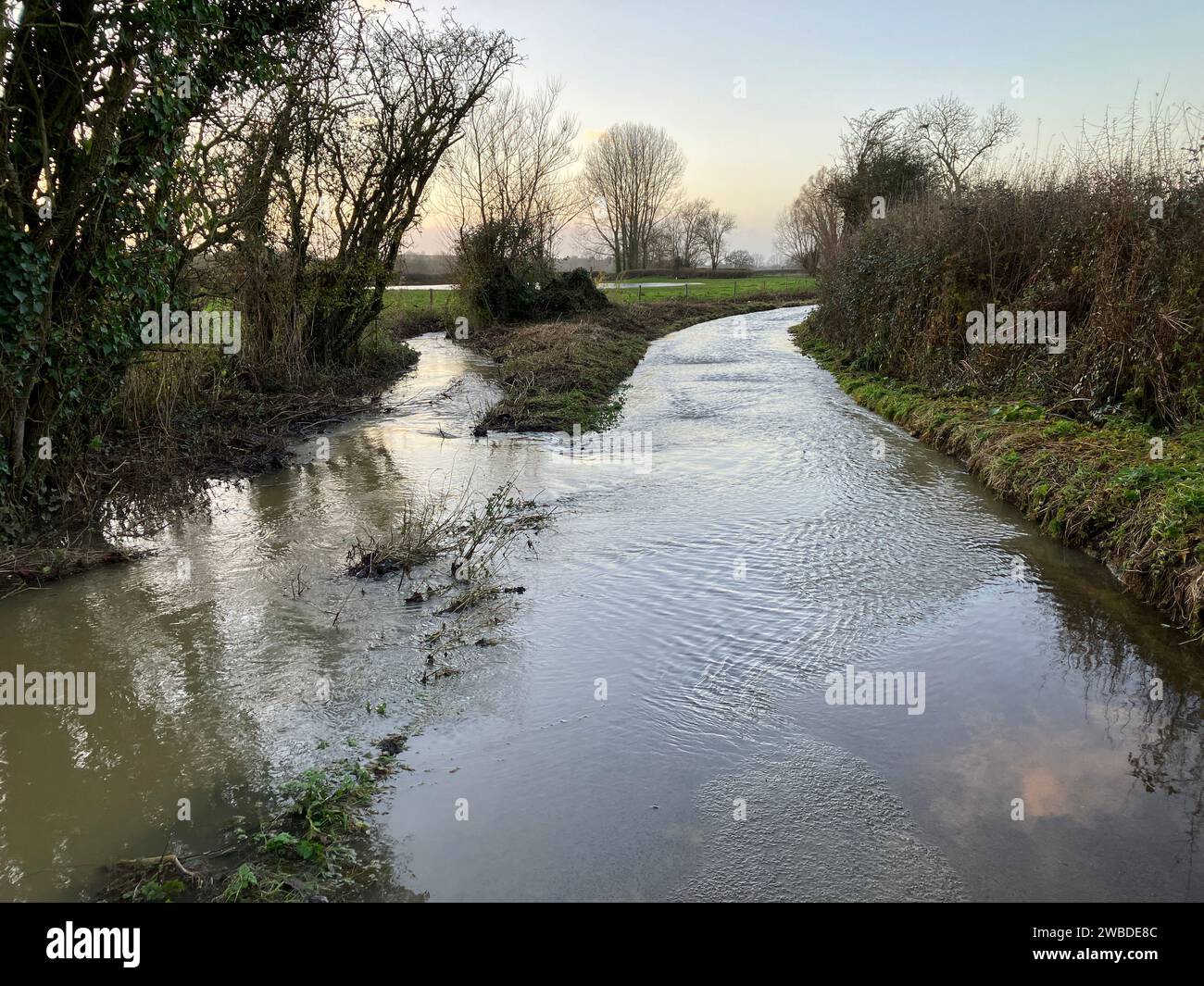 Überflutete Landstraße und Fluss mit geplatzten Ufer, verursacht durch starken Regen im Winter, Somerset, England Stockfoto