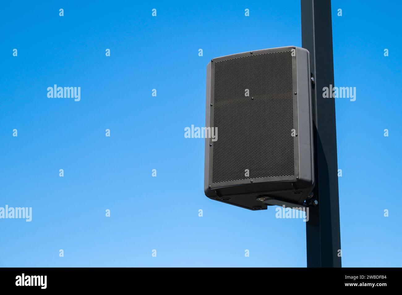 Lautsprecher, der an einem Stab im Freien vor blauem Himmel montiert ist, Stockfoto