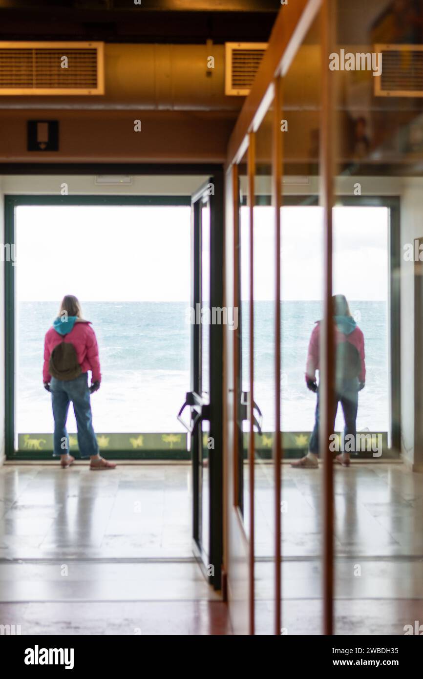 Frau, die aus dem Fenster schaut. Stockfoto