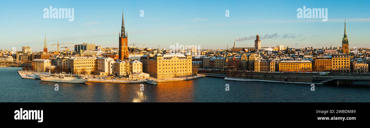 Großes, detailliertes Panorama der Altstadt von Stockholm mit Riddarholmen, im Winter mit Schnee und Morgensonne. Gelbe Farben, blauer Himmel, kaltes Wetter. Stockfoto