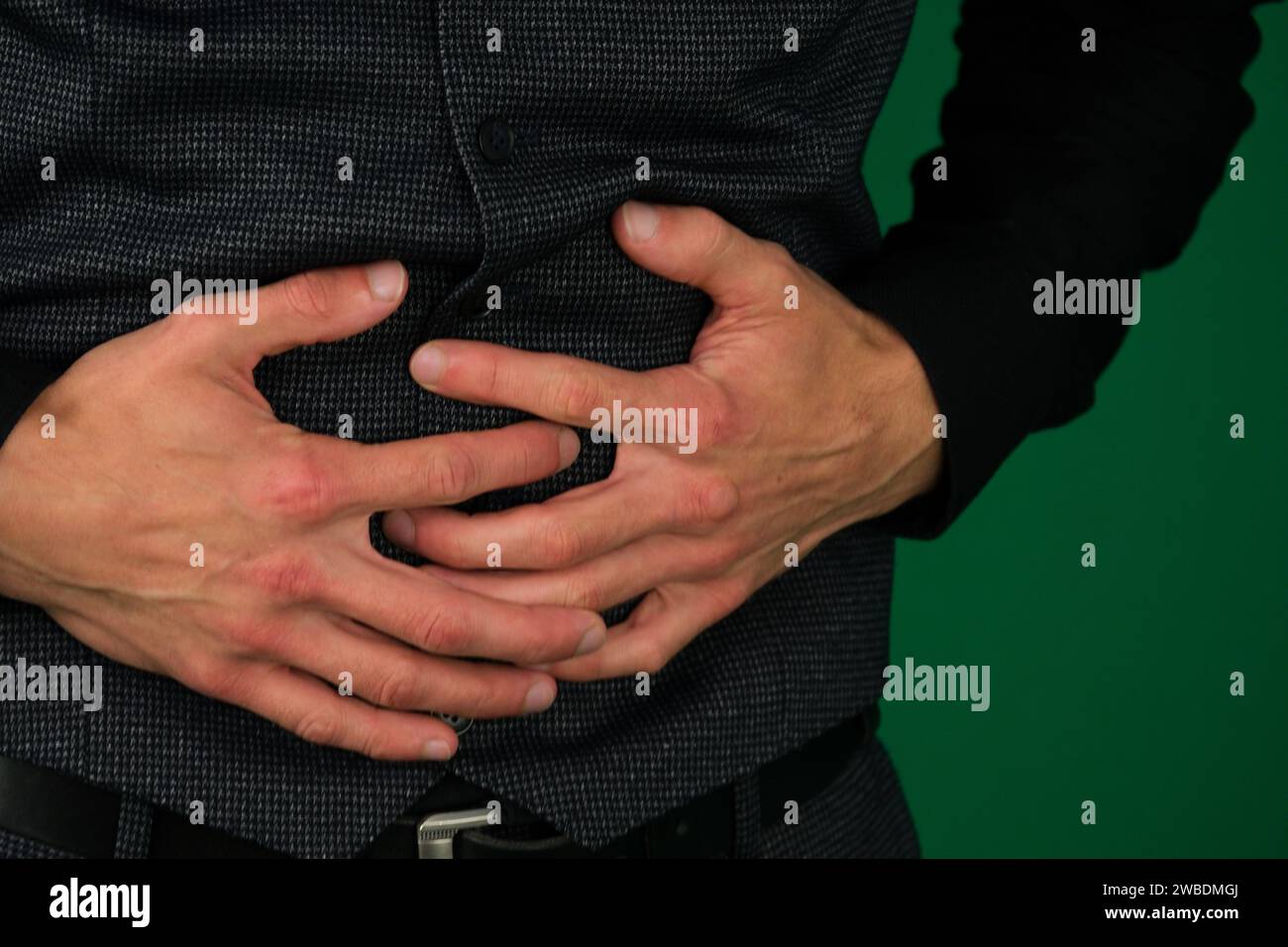 Emotionen eines gutaussehenden Mannes auf grünem Hintergrund Chromakey Nahaufnahme junger Mann Geschäftsmann Büromann mit Magenschmerzen. Hochwertige Fotos Stockfoto