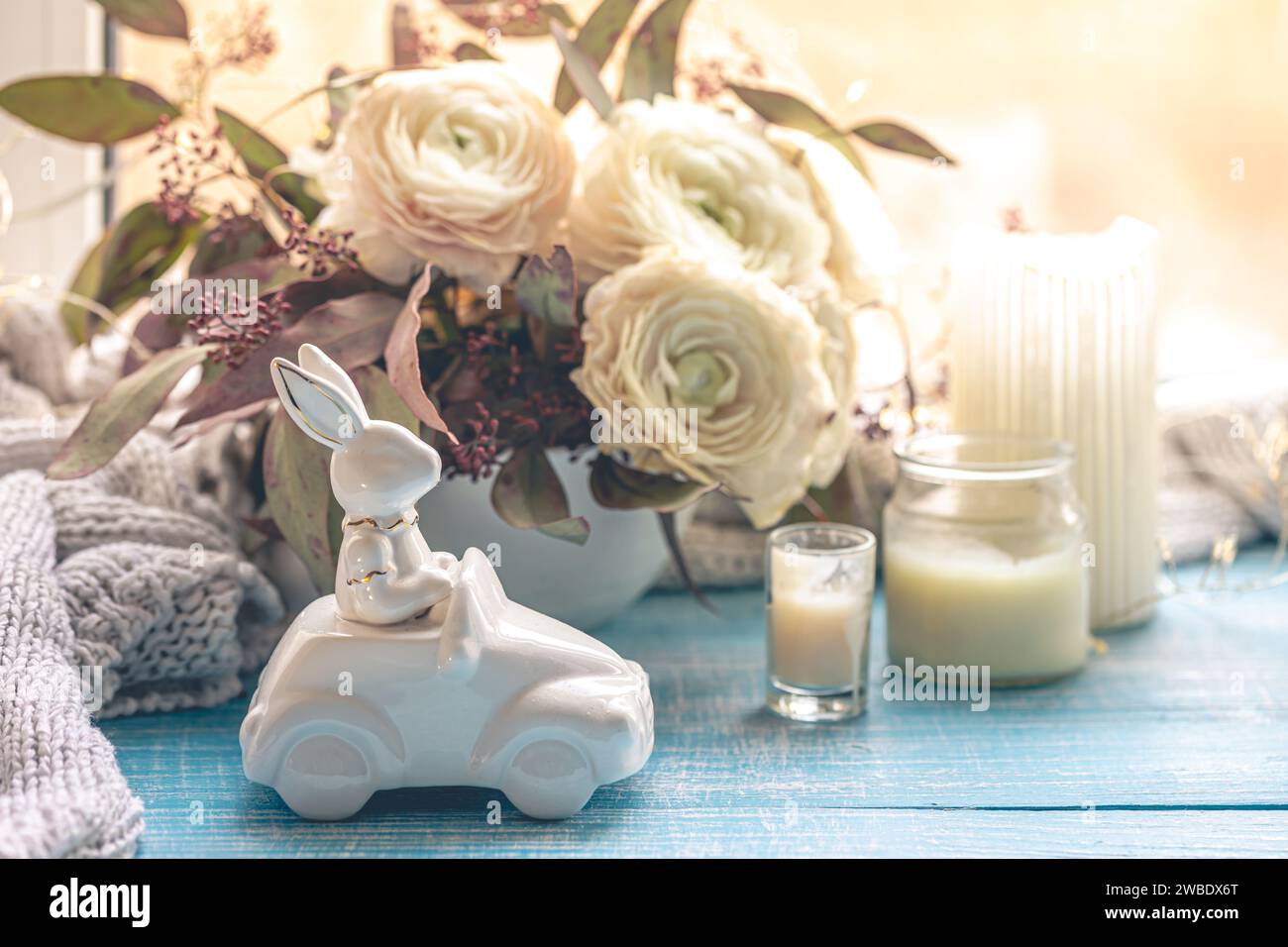 Festlicher Osterhintergrund mit dekorativem Keramikhasen und Blumen. Stockfoto