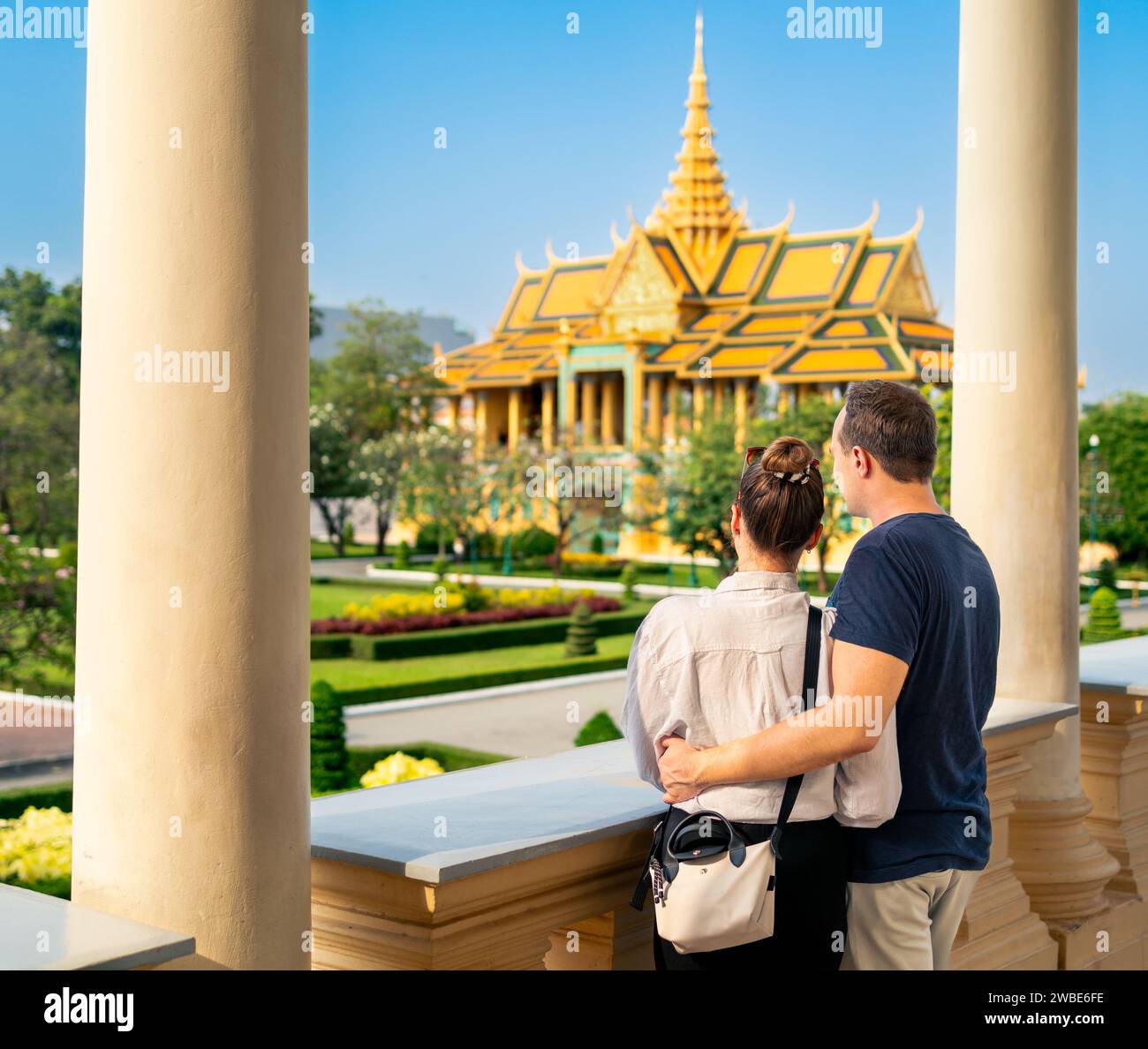 Touristenpaar in Phnom Penh, Kambodscha. Tourismus im Königspalast. Reisen Sie in Asien. Frau und Mann besuchen Wahrzeichen. Stadturlaub. Goldgebäude. Stockfoto