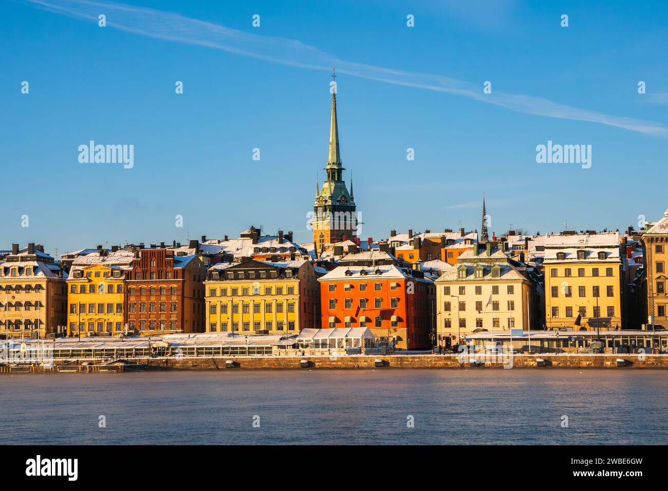 Ein kalter, sonniger Wintermorgen in Stockholm, mit den historischen Gebäuden der Altstadt (gamla stan) in der Nähe des Ufers. Deutscher Kirchturm Stockfoto