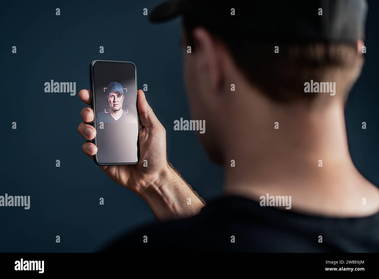 Gesichtserkennung mit Gesichtsscan am Telefon. Identifikation und Verifizierung zum Entsperren des Smartphones. Deep-Fake-Technologie. Mann mit Handy. Stockfoto