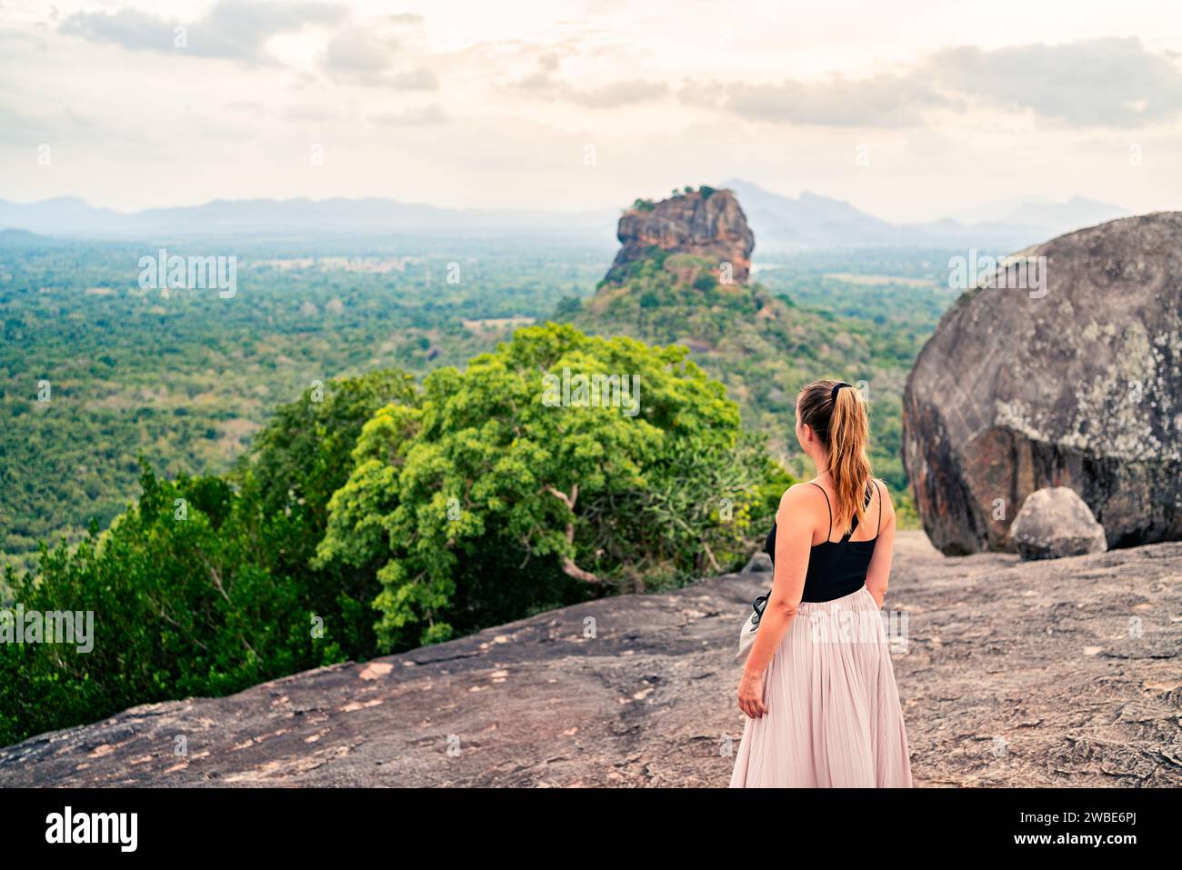 Frau in Sigiriya, Sri Lanka. Reisen Sie in die wunderschöne Natur. Berg- und Waldlandschaft. Glückliches Mädchen. Touristen, die den Lion's Rock von Pidurangala h aus betrachten Stockfoto
