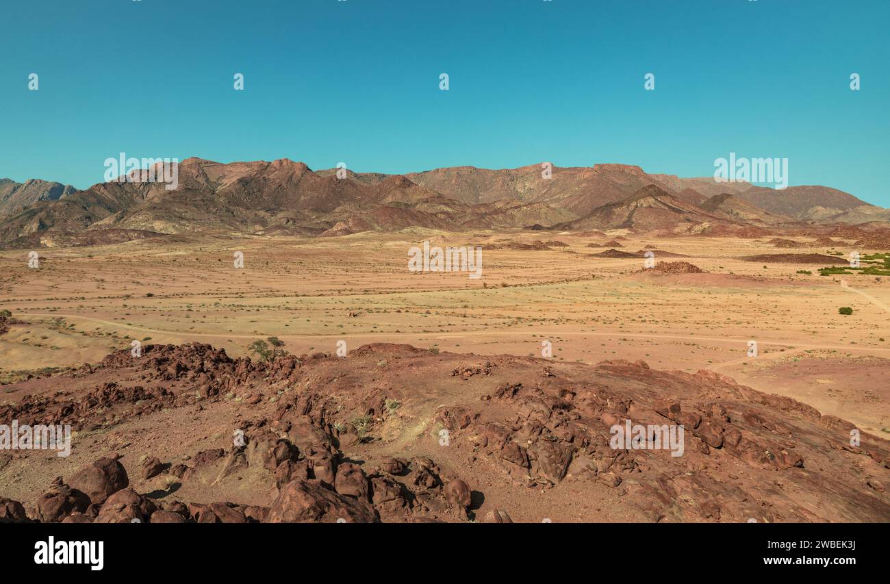 Schotterstraßen schlängeln sich durch ein felsiges Gebiet am Rande der Namib-Wüste im Erongo-Bezirk im Nordwesten Namibias. Stockfoto