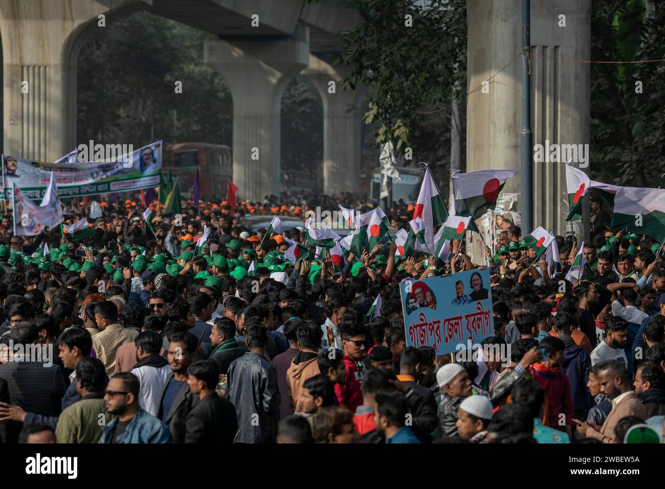 Dhaka, Bangladesch. Januar 2024. Demonstranten kommen mit Partybannern und -Fahnen während einer öffentlichen Kundgebung in Suhrawardy Udyan an an. Die Führer und Aktivisten der Awami-Liga versammelten sich in Suhrawardy Udyan, um an einer öffentlichen Kundgebung teilzunehmen, die zum Gedenken an den historischen Homecoming-Tag des Vaters der Nation, Bangabandhu Scheich Mujibur Rahman, organisiert wurde. Quelle: SOPA Images Limited/Alamy Live News Stockfoto