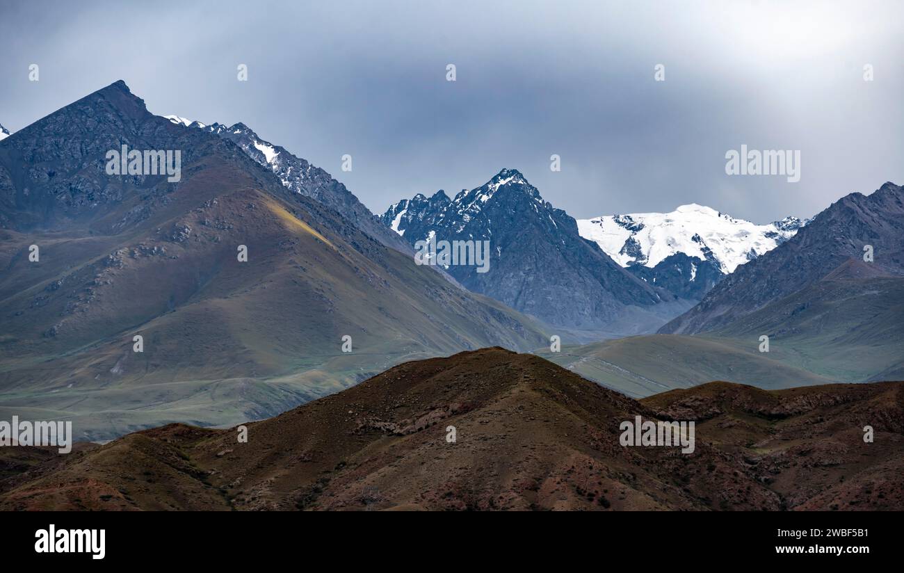 Dämmerung über schneebedeckten Berggipfeln und steilen Hängen, Kirgisistan Stockfoto
