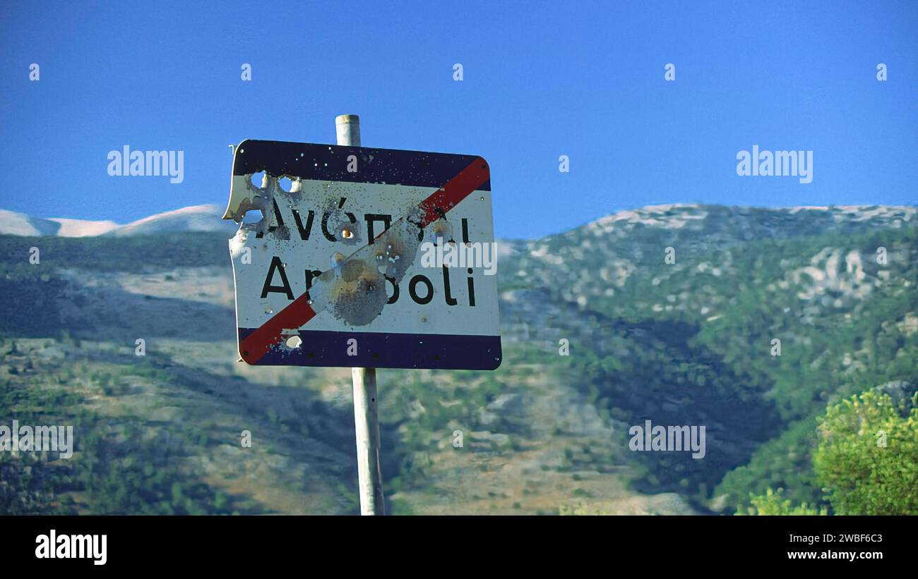 Ein beschädigtes Straßenschild mit Schusslöchern, im Hintergrund eine malerische Berglandschaft, Anopolis, Sfakia, Westkreta, Kreta, Griechenland Stockfoto