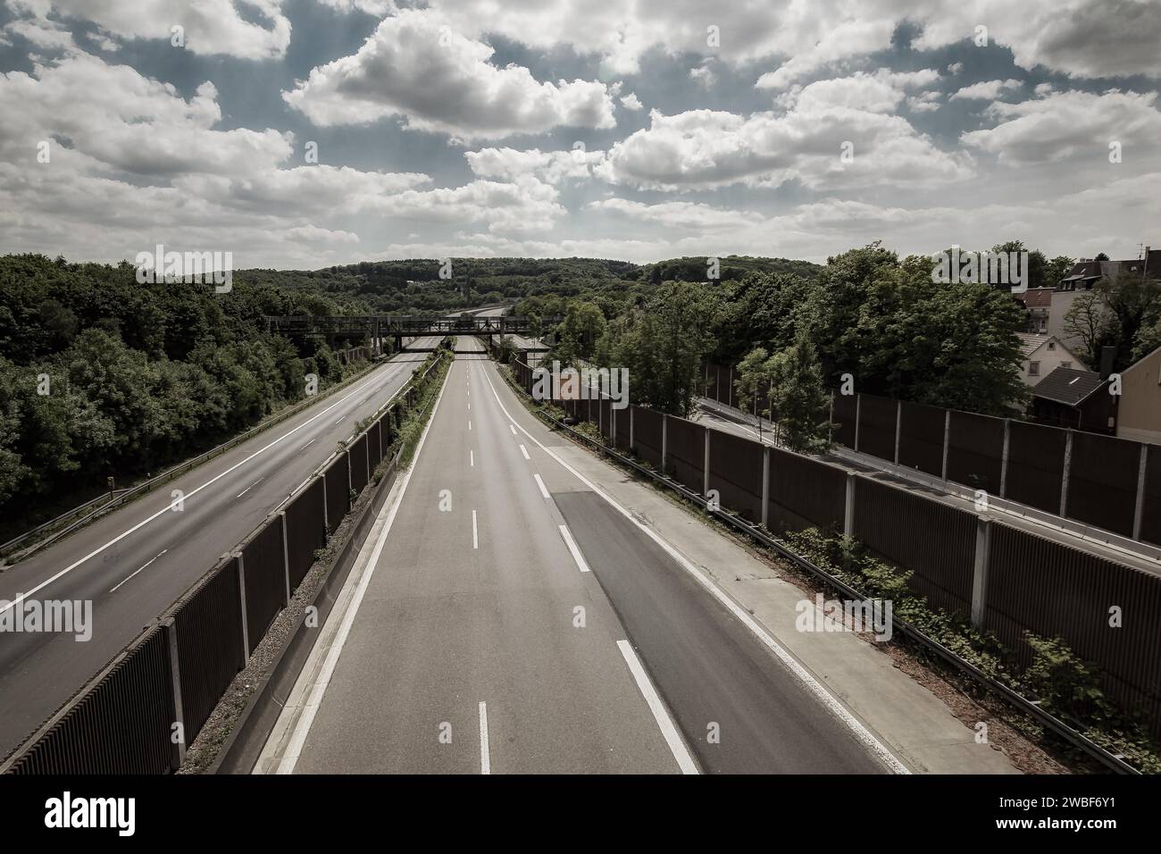 Blick auf eine leere Autobahnbrücke mit Geländer, umgeben von Bäumen unter bewölktem Himmel, Sonnborner Kreuz, A46, Wuppertal Sonnborn, Nord Stockfoto