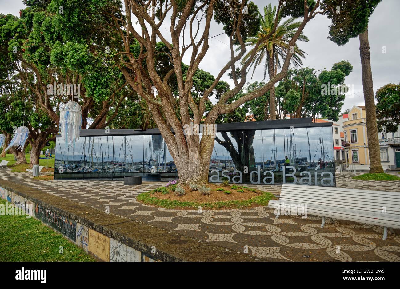 Modernes Glasgebäude gegenüber historischen Häusern in einem grünen Park, Horta, Faial Island, Azoren, Portugal Stockfoto