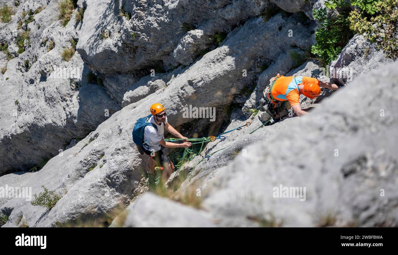 Zwei Kletterer klettern eine steile Felswand hinauf, alpines Klettern mit Seil, Arco, Italien, KI generiert Stockfoto