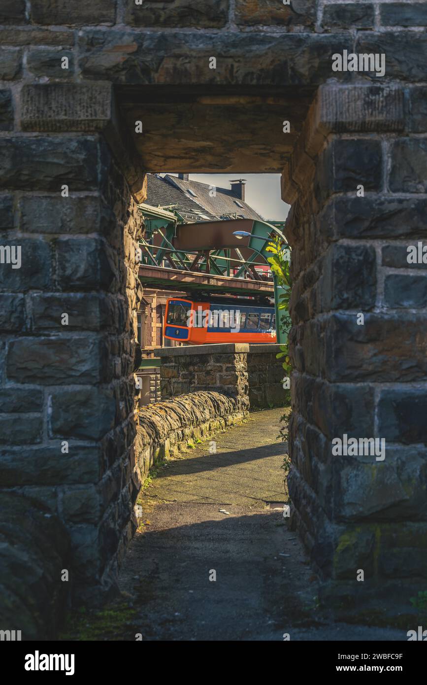 Schwebebahn fotografiert durch einen Steinbogen, städtische Umgebung im Hintergrund, Schwebebahn Wuppertal Sonnborn, Nord Stockfoto