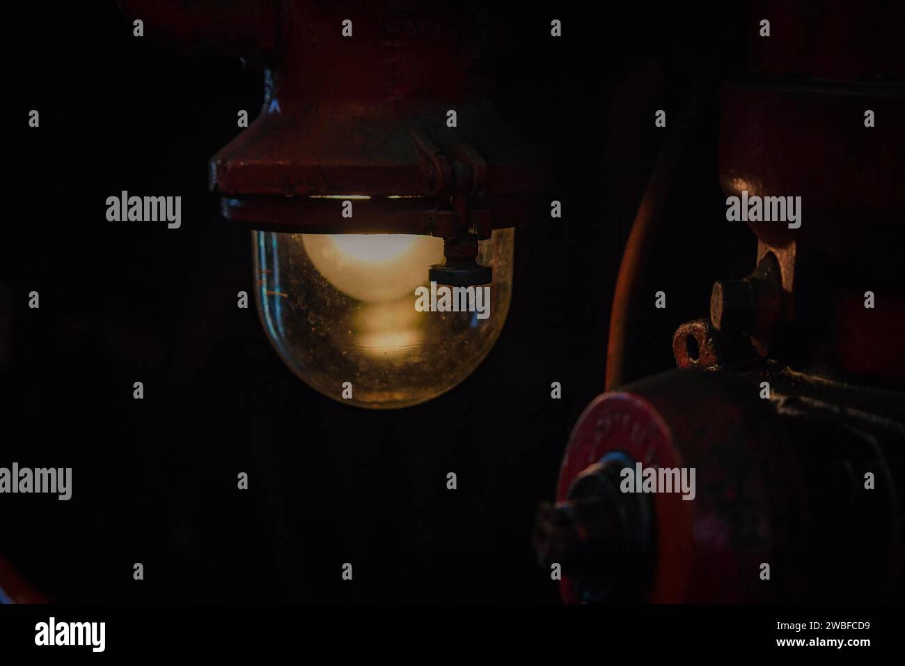 Ein atmosphärisches Licht aus einer antiken Lampe in einem dunklen Teil einer Lokomotive, Bahnbetriebswerk Dahlhausen, Lost Place, Dahlhausen, Bochum, Nord Stockfoto