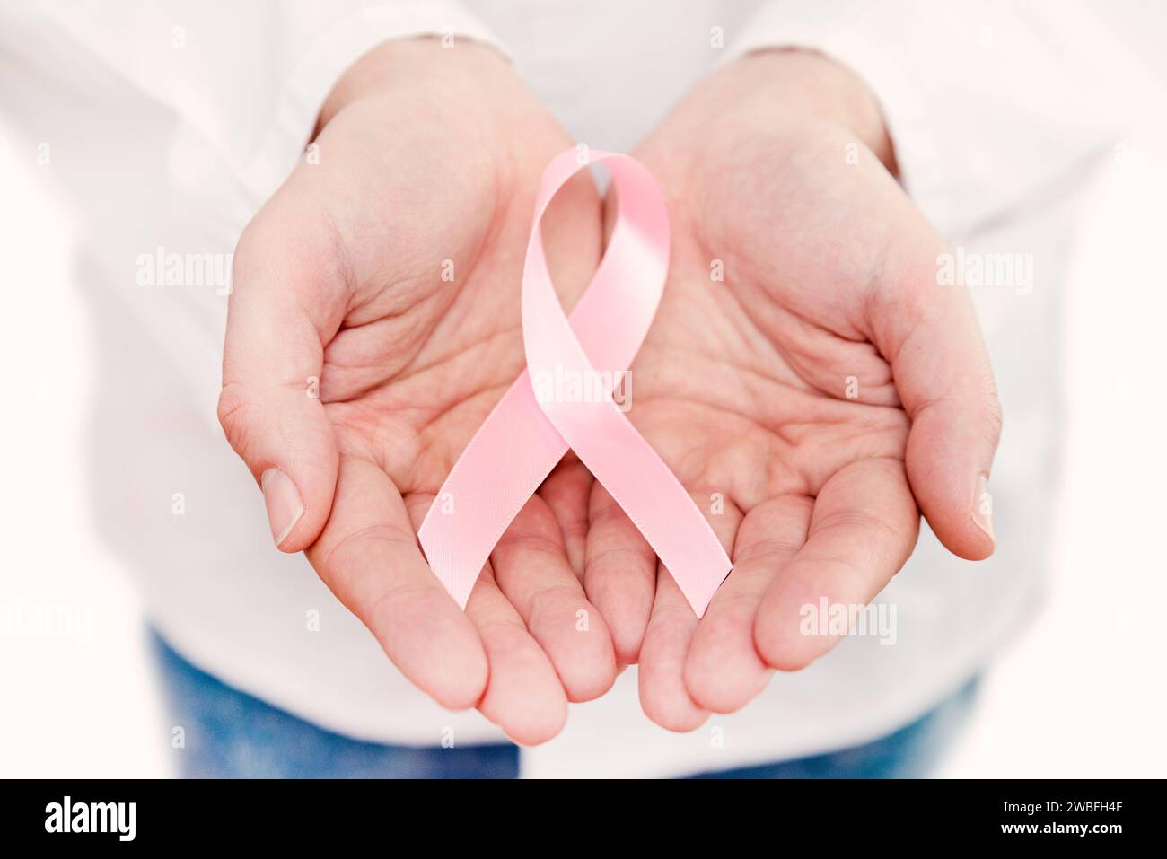 Hand mit rosafarbenem Brustkrebswarnband mit Kopierraum Stockfoto