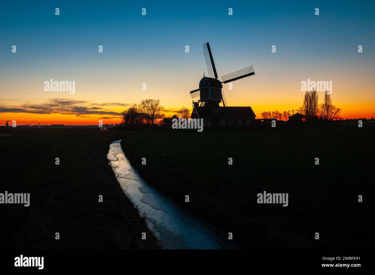 Klassische Windmühle in der niederländischen Landschaft an einem kalten winterlichen Abend Stockfoto