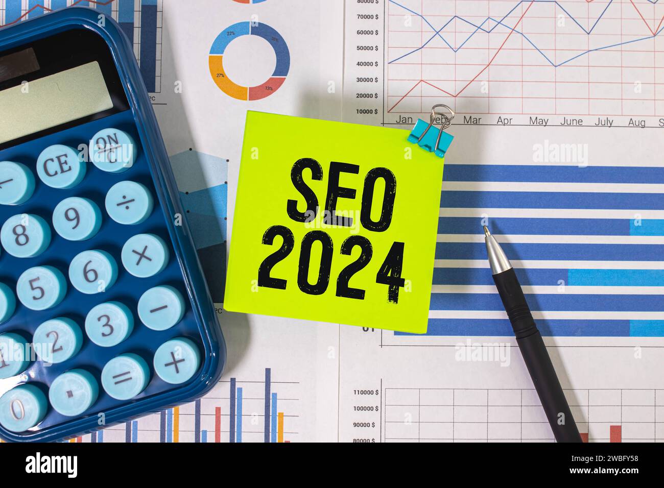 Auf der Lupe befinden sich Papierstreifen mit der Aufschrift SEO 2024. Stockfoto