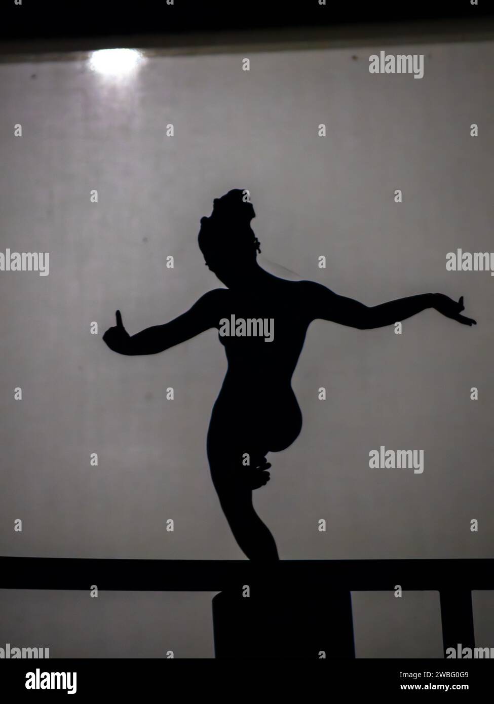 Die Silhouette einer Person wird durch das Licht beleuchtet, das durch das Fenster geht Stockfoto