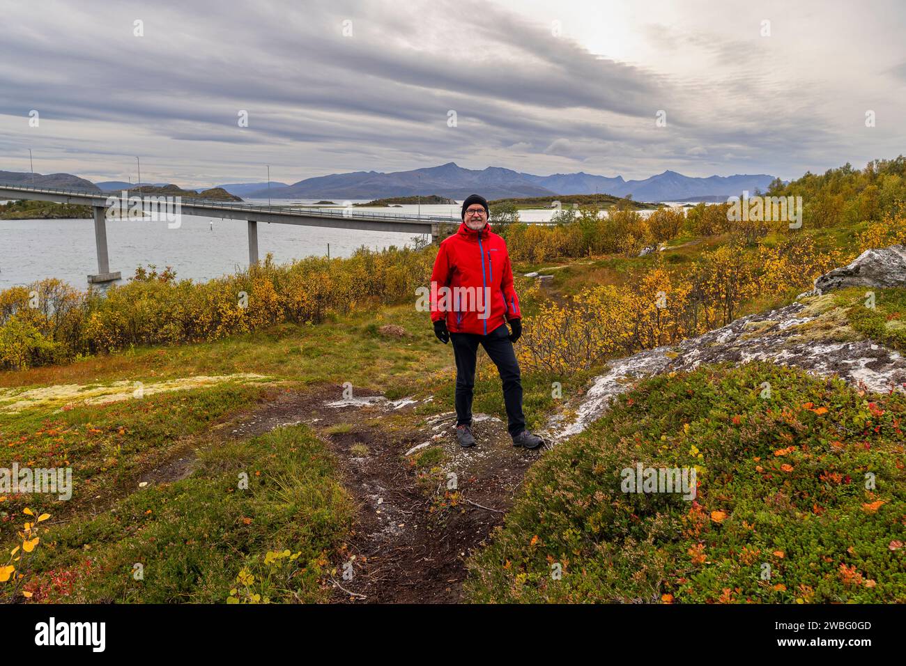 Wandermann in der herbstlichen Natur Norwegens. Wandern am Fjord und den Bergen auf der Insel Kvaløya in Troms, Wanderer auf dem Weg, Wanderer Paradies Stockfoto
