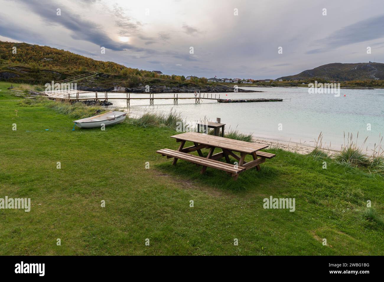 Sitzbereich am Strand von Sommarøya, Grillbereich am Ufer des Nordatlantiks, in Troms, Norwegen. Parkbank aus Holz mit Tisch, Esstisch, Kamin Stockfoto
