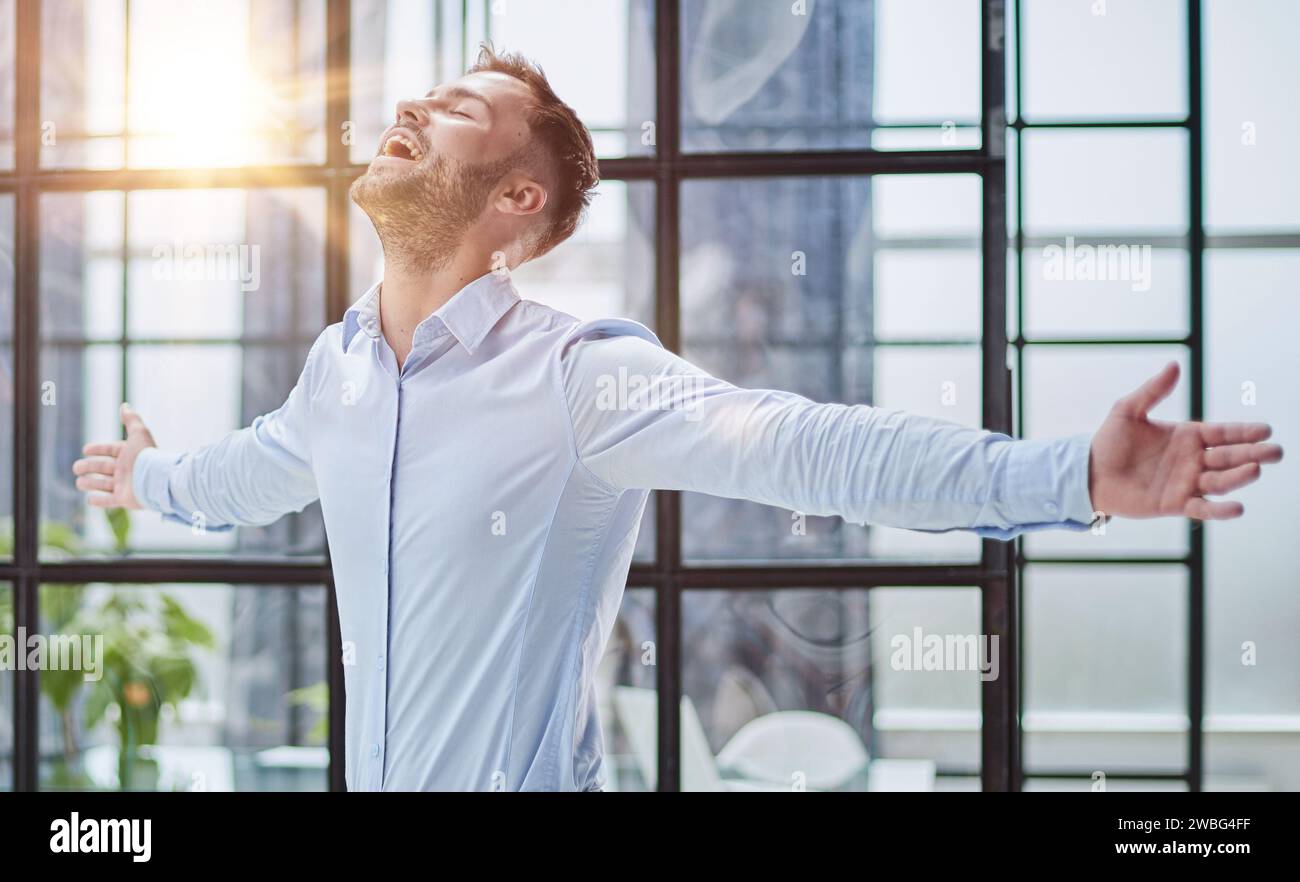 Porträt mit Kopfschuss und lächelndem selbstbewusstem Geschäftsmann im modernen Büro Stockfoto