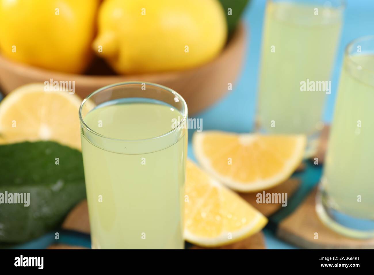 Leckerer Limoncello-Likör und Zitronen auf dem Tisch, Nahaufnahme. Leerzeichen für Text Stockfoto