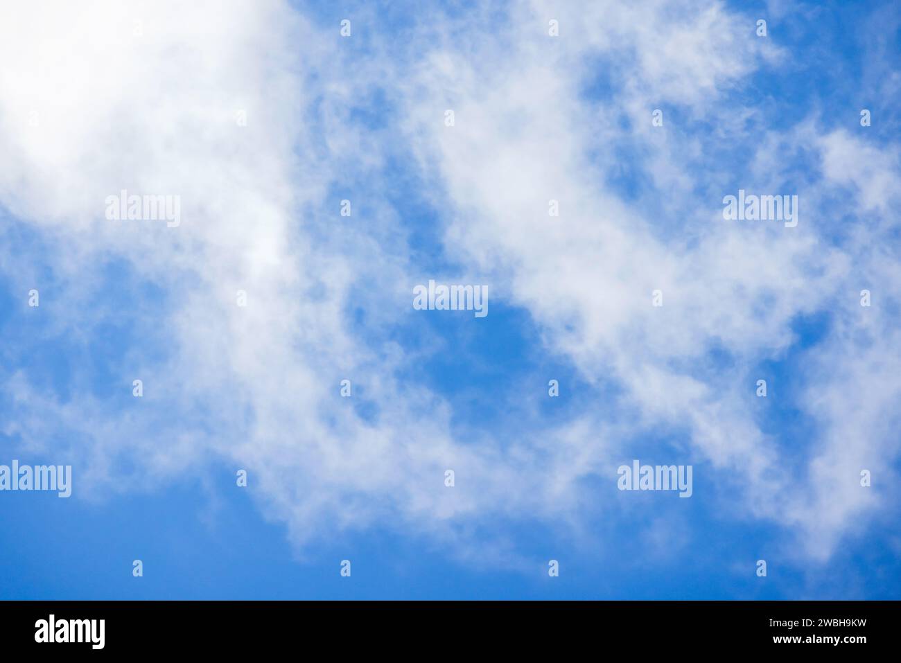 Blauer Himmel mit weißen Altocumulus-Wolken, natürliches Hintergrundfoto an einem sonnigen Tag Stockfoto