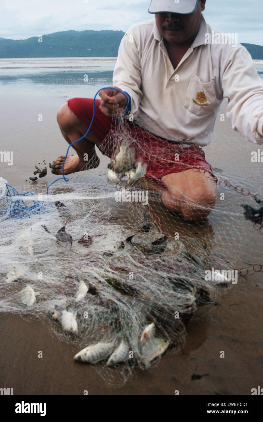 Fischer an der Küste des pacitanischen Gebiets ernten die Fische in ihren Netzen Stockfoto