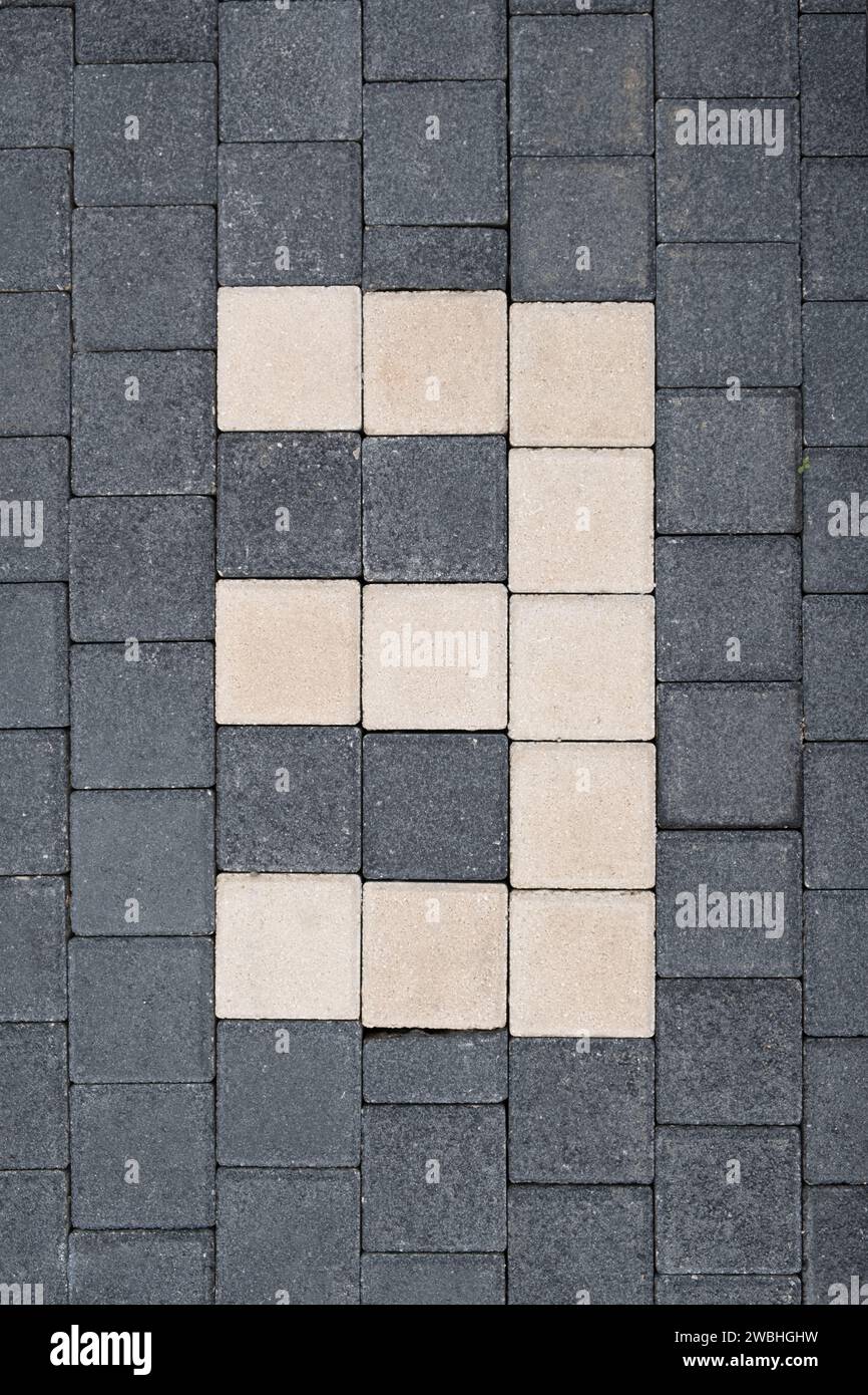 Nummer drei 3 über den Parkplatz in einem Parkplatz für die Parkorganisation. Mit Straßenfliesen bedeckte Oberfläche für Fahrzeuge. Parkmöglichkeiten. Stockfoto