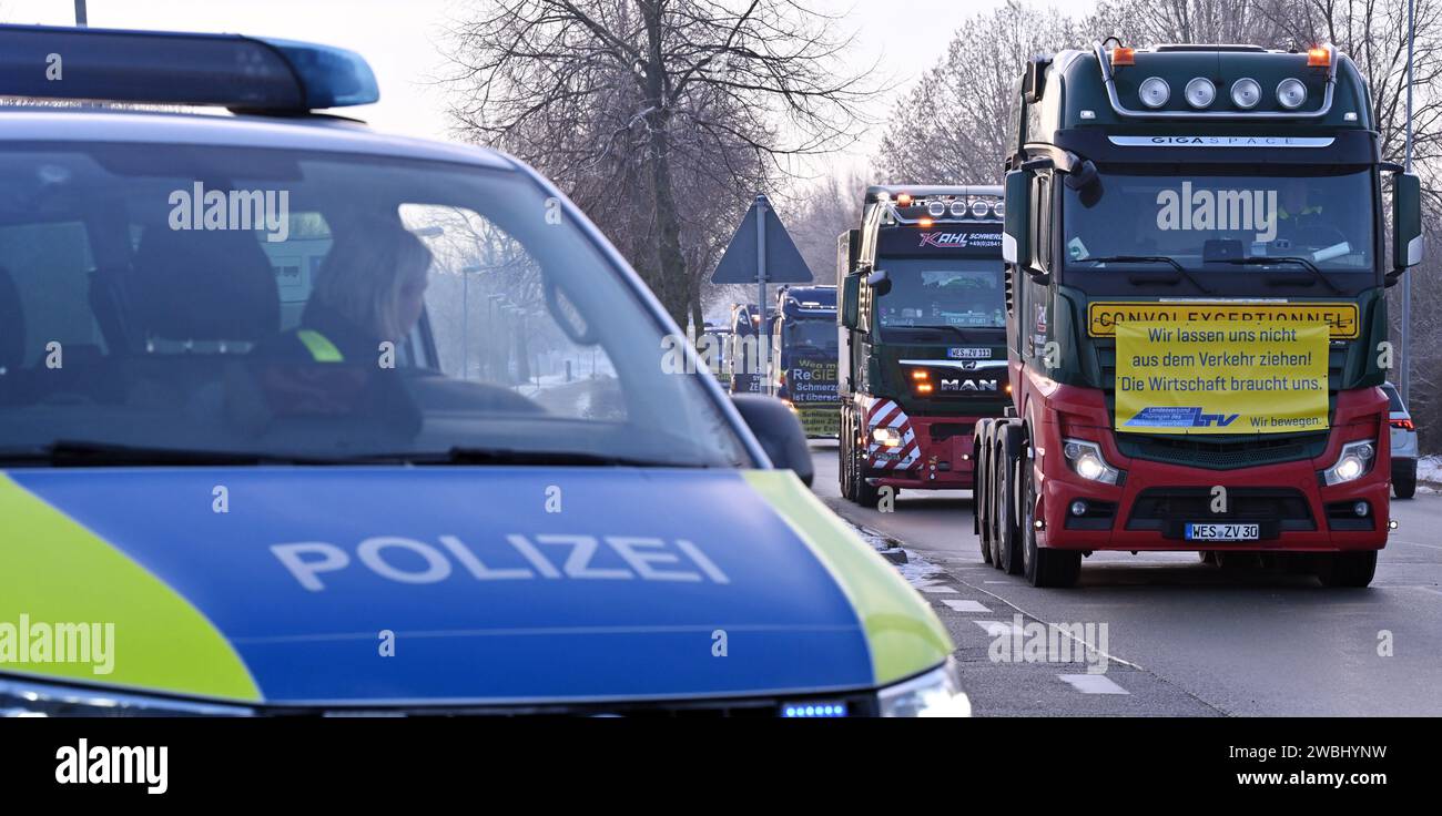 Nohra, Deutschland. Januar 2024. Lastwagen mit Bannern fahren im Konvoi durch Nohra bei Weimar. Neben den protestierenden Bauern hat auch die staatliche Transportindustrie einen Konvoi gestartet. Die Spediteure wollten gegen die Doppelbelastung der Lkw-Maut und der CO2-Steuer protestieren. Rund 150 Fahrzeuge nahmen an dem Protest Teil. Der rund fünf Kilometer lange Konvoi rollte von Erfurt über Weimar nach Jena. Quelle: Martin Schutt/dpa/Alamy Live News Stockfoto