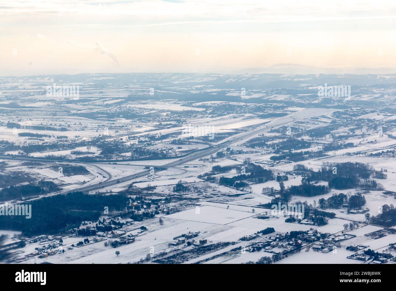 Krakau, Polen, 11. Januar 2024. Arial Blick von einer Luftverschmutzungsebene über Krakau und seinen Vororten, als die Temperaturen in den letzten Tagen deutlich unter 0 °C fielen. Die Luftverschmutzung wurde für sehr ungesund erklärt und PM2,5, und die PM10-Konzentration war viel höher als die jährlichen Luftqualitätsleitlinien DER WHO. Die Verschmutzung ist eine Kombination aus Windmangel und niedrigen Temperaturen, die die Stadt und ihre Bewohner zwangen, ihre Häuser mehr zu heizen. Stockfoto