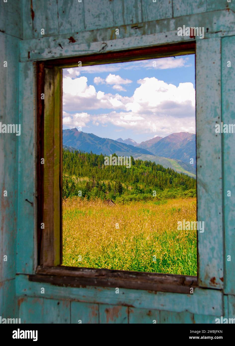 Ein malerischer Blick auf die grünen Hügel durch das offene Fenster Stockfoto