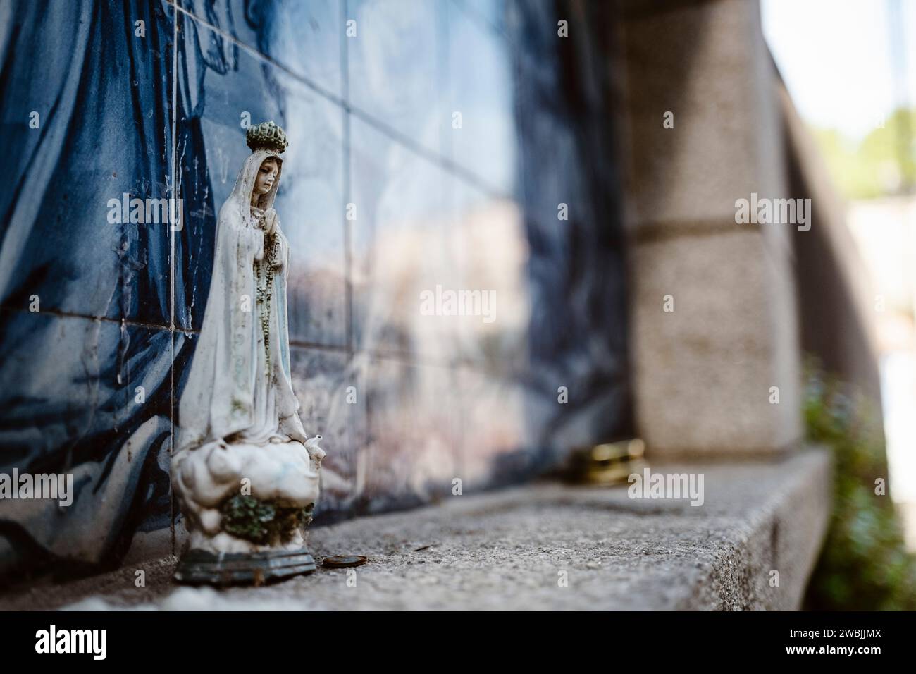 Statue der Heiligen Maria mit religiösem Hintergrund aus traditionellen portugiesischen Fliesen, Porto, Portugal Stockfoto
